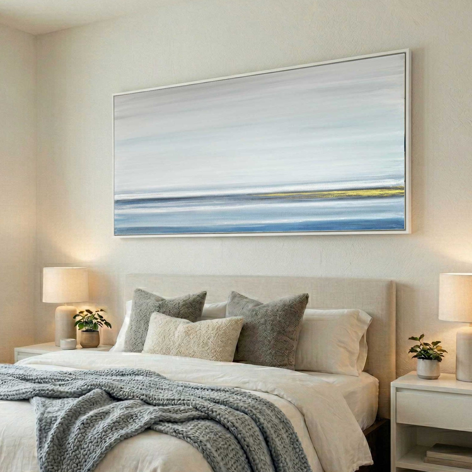 blue white gold panoramic painting in white frame above bed