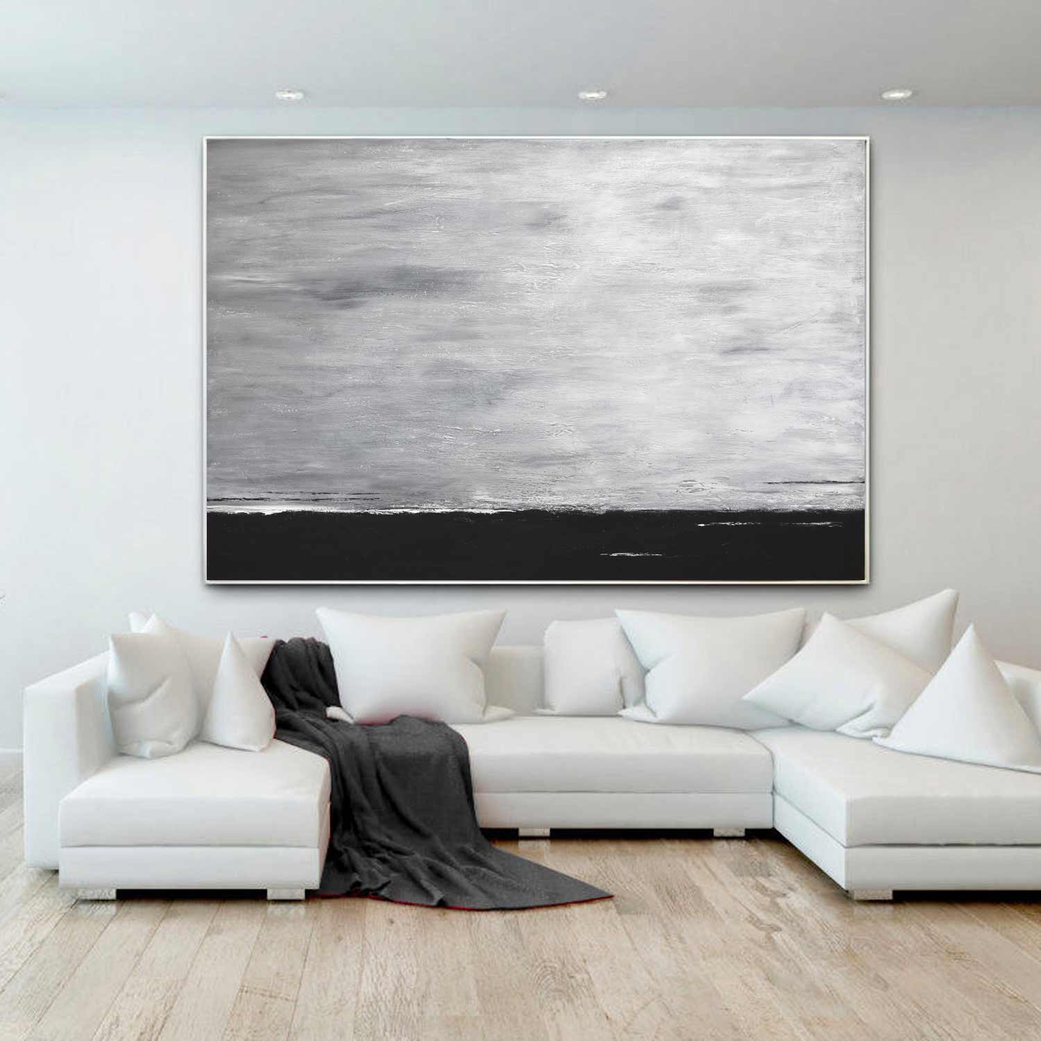 white and black large artwork above couch