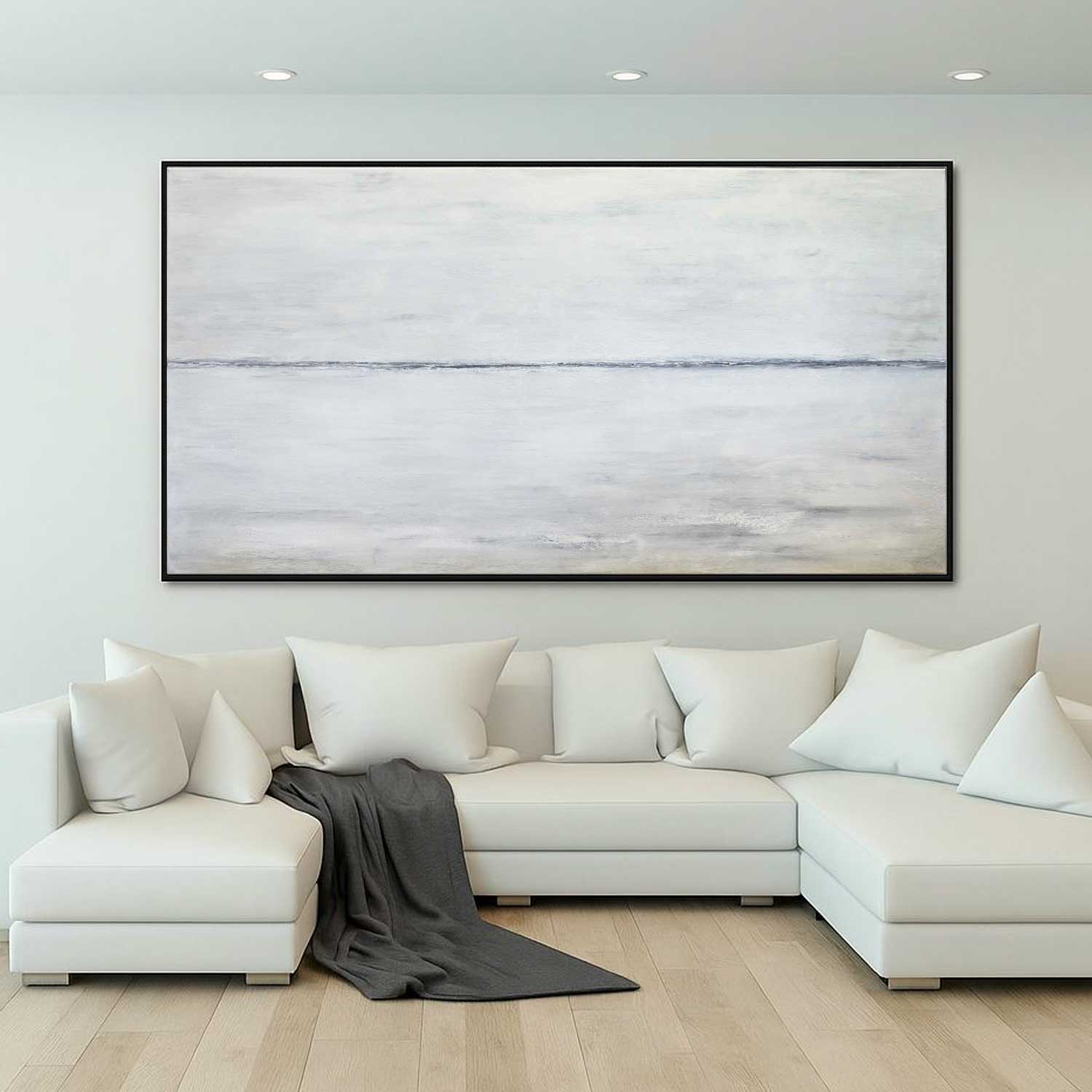 Modern living room with a white sectional sofa and abstract painting on the wall.