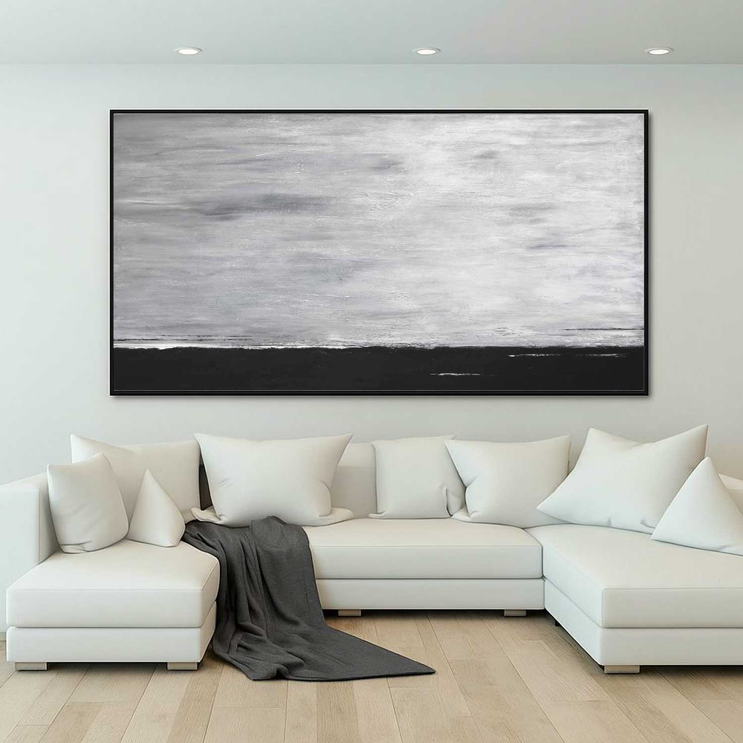 White sectional sofa with a large abstract painting on the wall in a modern living room.